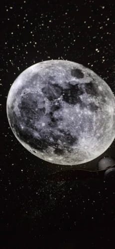 Luna llena proyectada en el techo de una pieza a oscuras