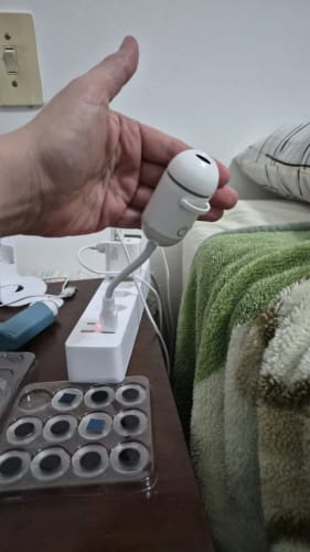 El proyector en la mano junto a la bandeja de discos