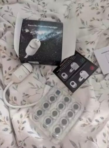 Unboxing sobre la cama: la caja, el proyector y la bandeja de discos