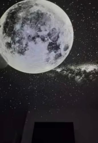 Luna llena proyectada en el techo de una pieza a oscuras